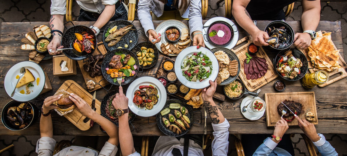 Colleagues sharing dishes around a long dinner table
