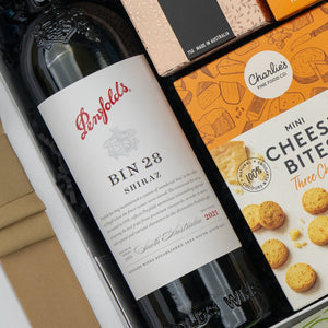 The Hamper Boutique Co’s Penfolds Celebration Hamper features a 2021 Penfolds Bin 28 Shiraz from South Australia, paired with Charlies Mini Cheese Bites and another snack, beautifully packed in a gift box.