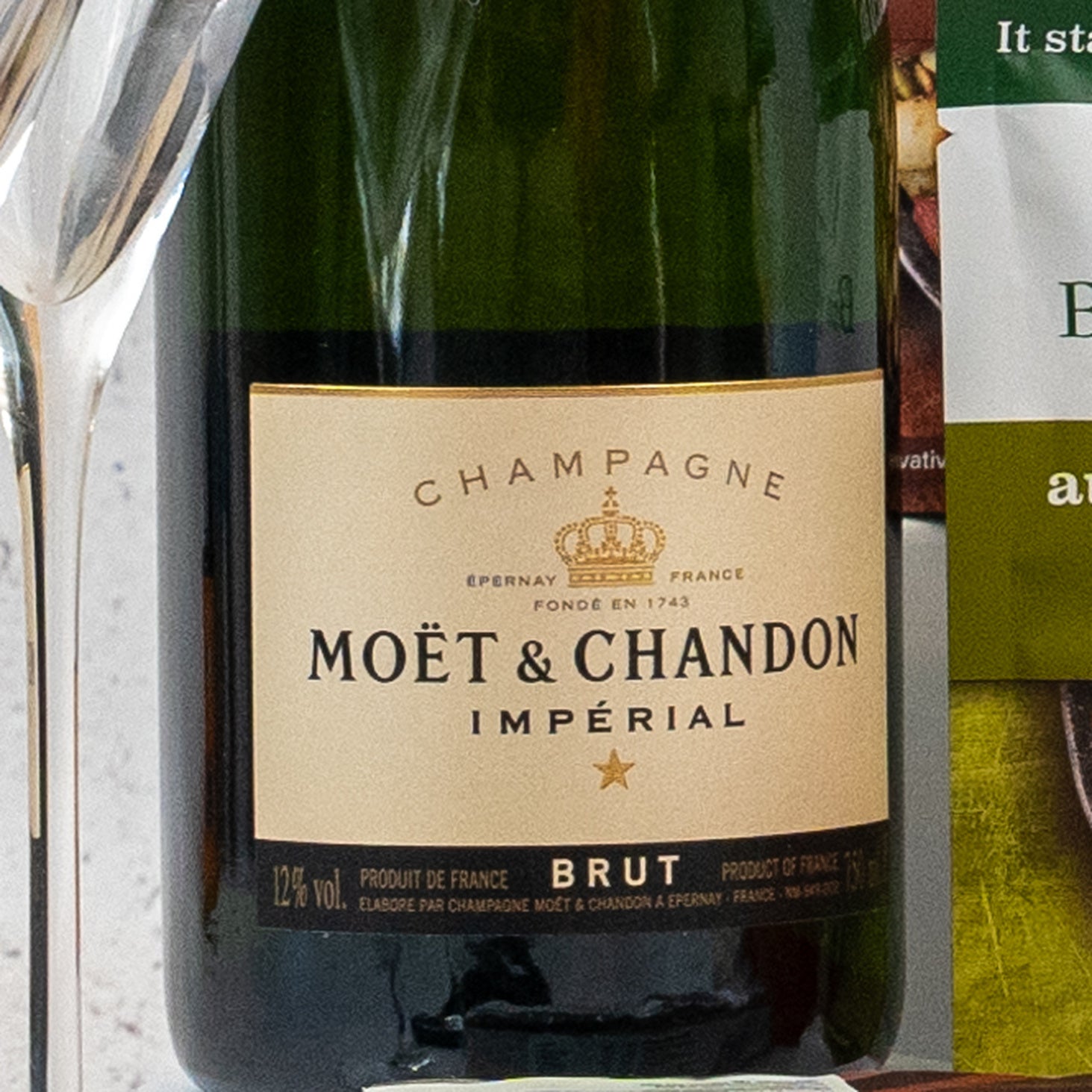 A close-up of The Hamper Boutique Co Ultimate Homeware Gift Hamper, featuring its signature packaging next to a glass and part of another item on the right.