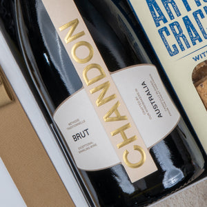 A close-up of The Hamper Boutique Co's Chandon Celebration Hamper, featuring a bottle of Chandon Brut sparkling wine and artisan crackers arranged in an elegant gift box.