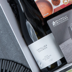 The Hamper Boutique Co Epicurean Delights Hamper includes a Catalina Sounds 2021 Sauvignon Blanc, Maxwell & Williams glassware, and a cookie package—perfect for gifting.