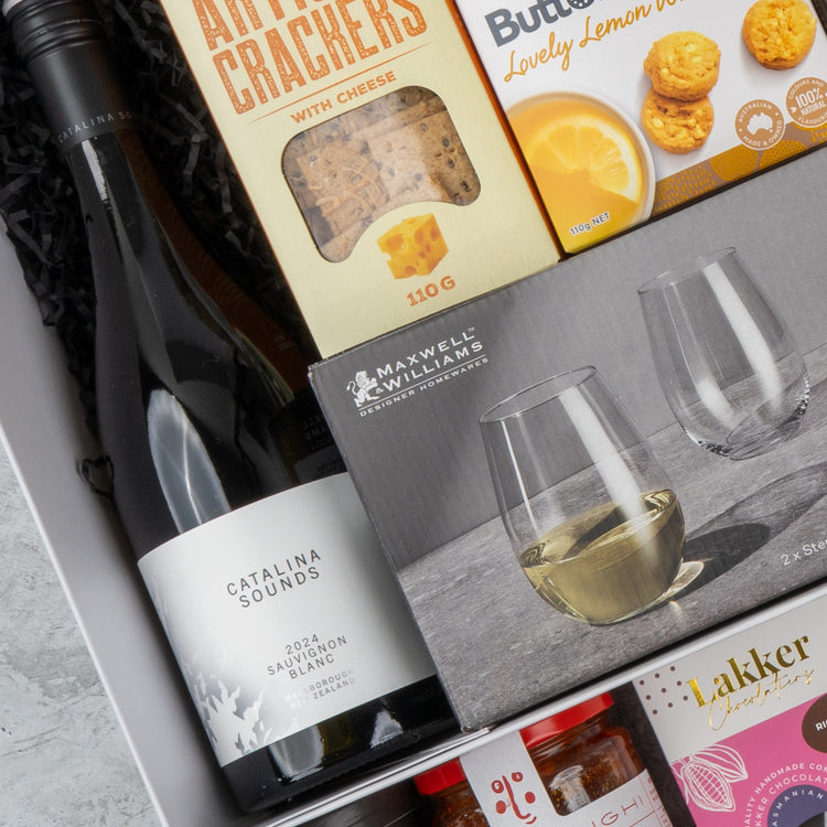 The Ultimate Gourmet Collection Hamper by The Hamper Boutique Co includes Catalina Sounds Sauvignon Blanc, two stemless wine glasses, artisan crackers, Butter Lovely Lemon cookies, and jars of chutney and jam.