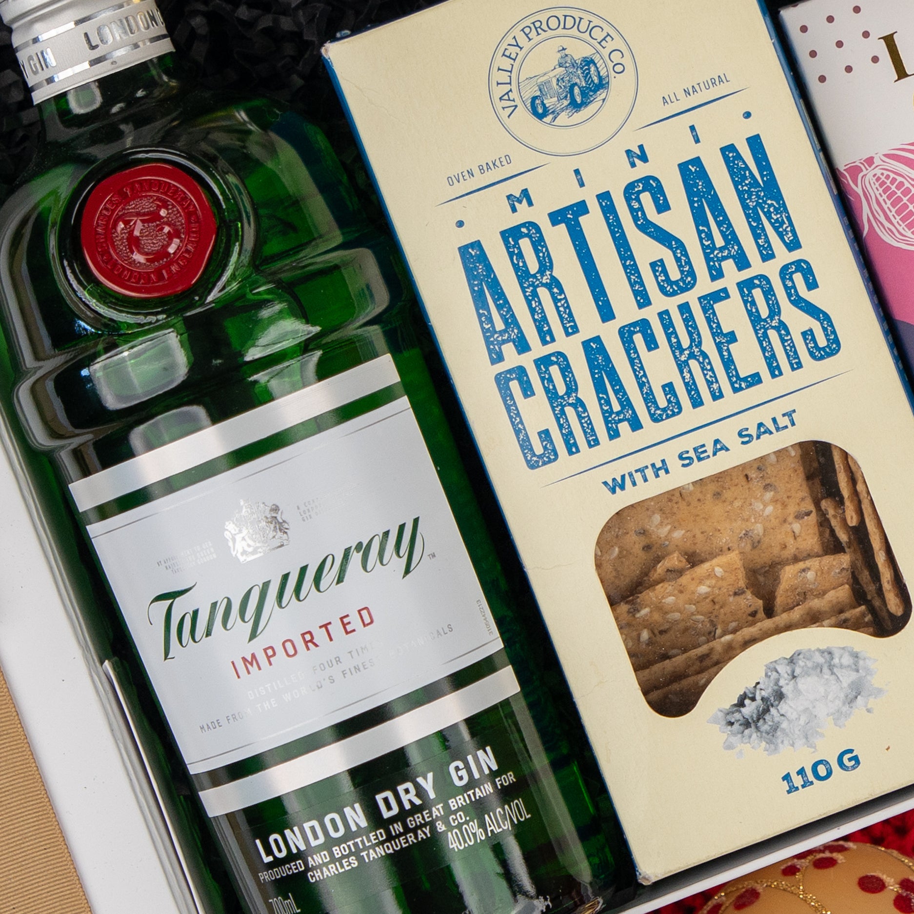 The Hamper Boutique Co Cheers & Tonic gift box includes a bottle of gin and a box of sea salt mini artisan crackers.