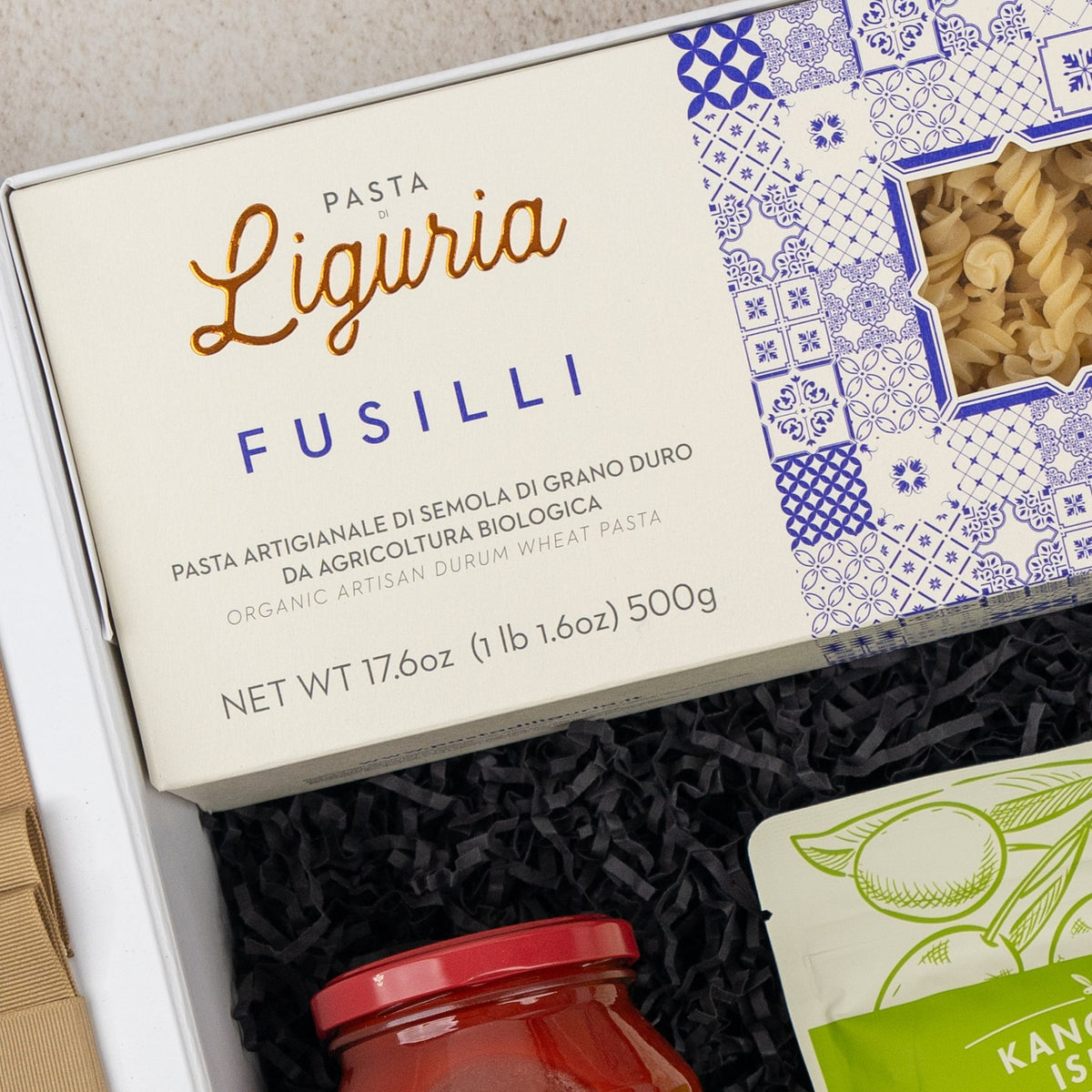 Mediterranean Pantry Hamper: Liguria fusilli and a jar of red sauce in black shredded paper