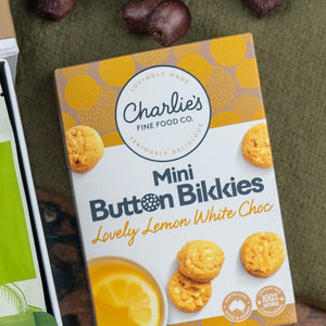 A Glenmorangie Premium Selection Hamper by The Hamper Boutique Co is displayed on a green surface, with packaging featuring images of premium treats and whisky.