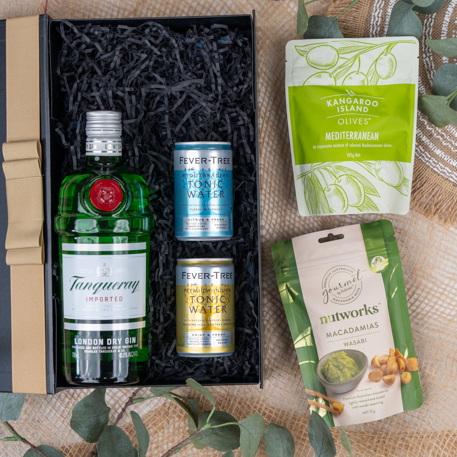 The Hamper Boutique Co's Tanqueray Delights Hamper features Tanqueray London Dry Gin, two Fever-Tree tonic waters, and comes with Mediterranean olives and wasabi macadamia nuts in green and yellow packets.