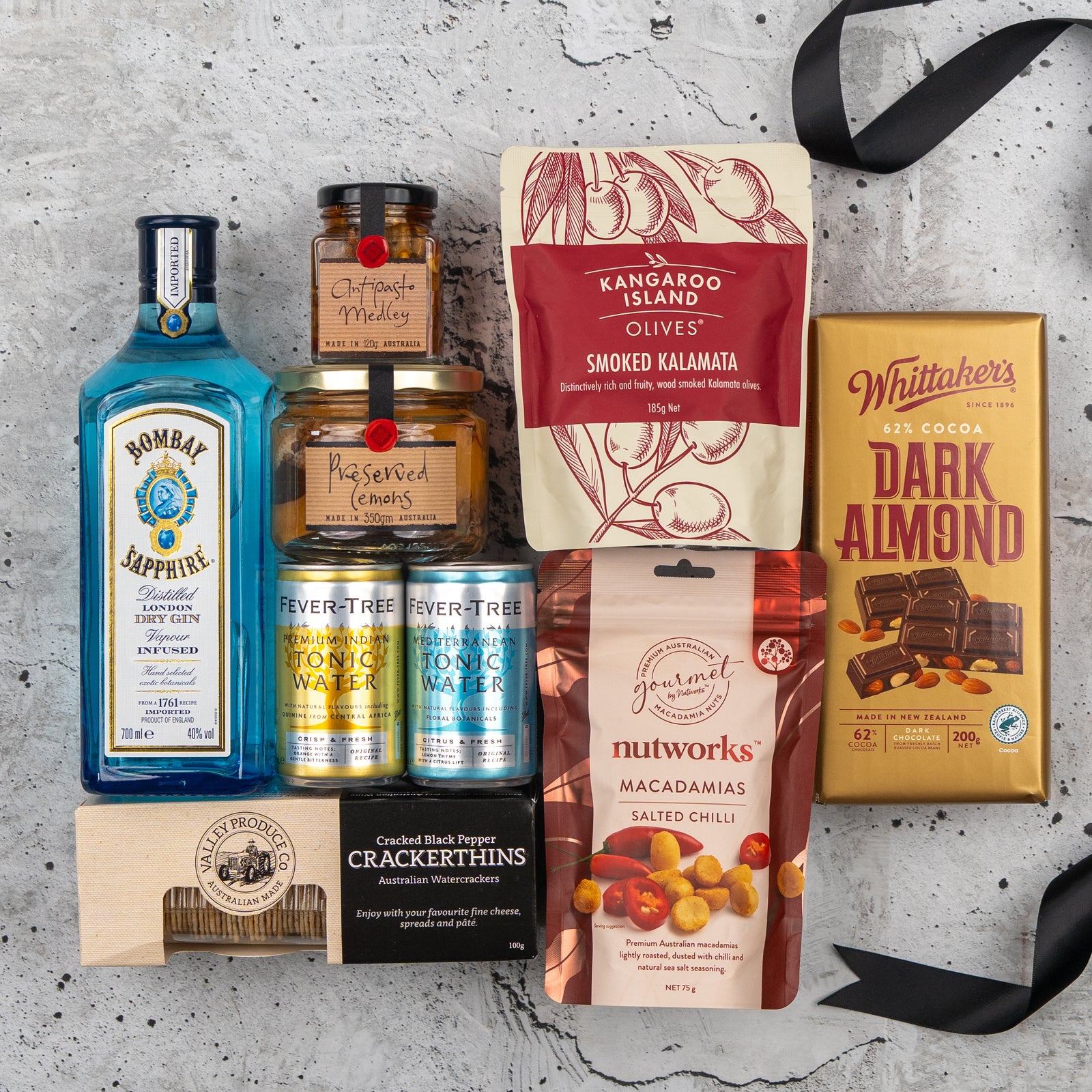 The Hamper Boutique Co’s Bombay Sapphire Gin Explorer’s Hamper features gin, Fever-Tree tonic, almond chocolate, Kalamata olives, chili macadamias, crackers, honey, and preserved peaches in a stylish gift box.