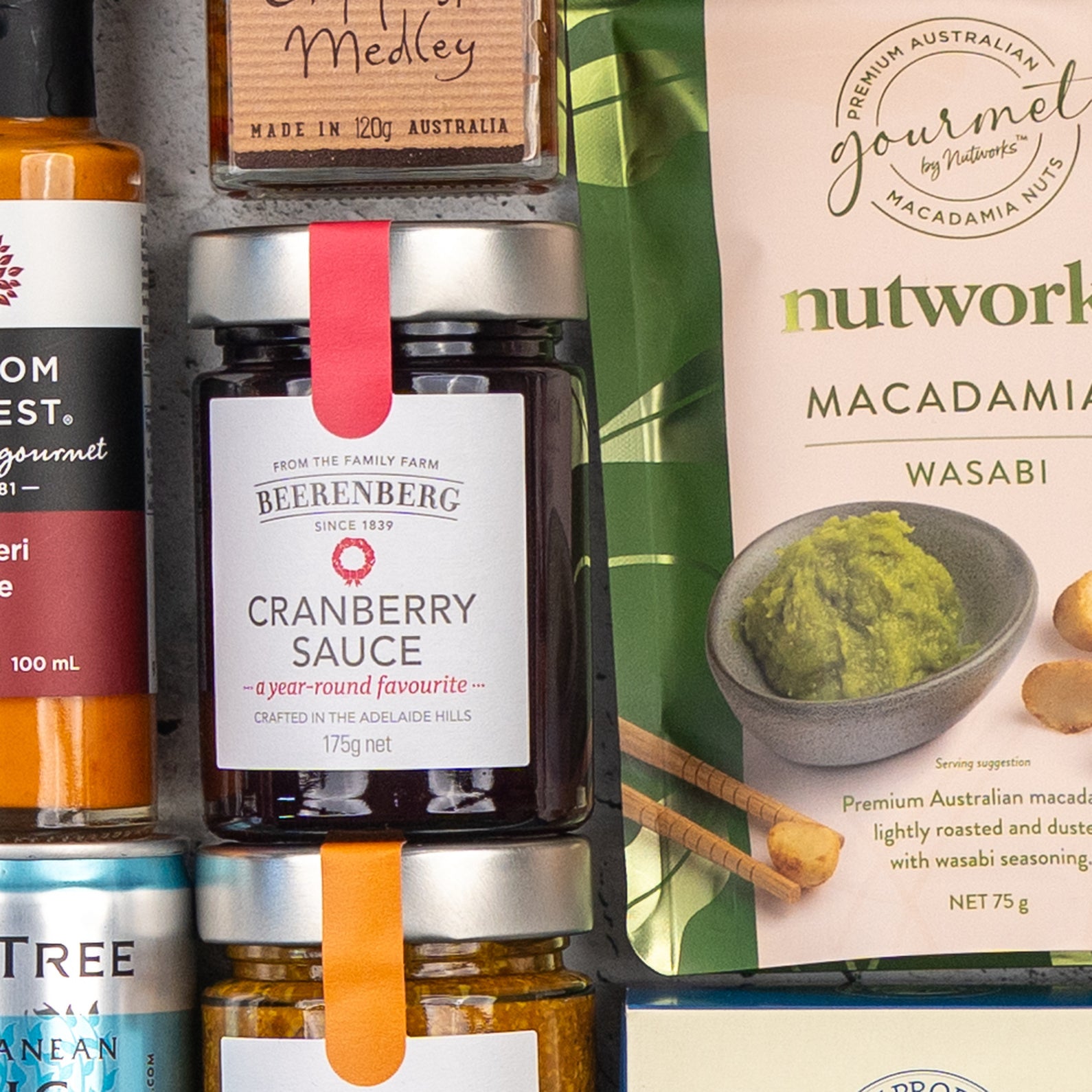 A close-up of Four Pillars Premium Gin Hamper by The Hamper Boutique Co, featuring neatly arranged gourmet products with colorful labels highlighting unique flavors.