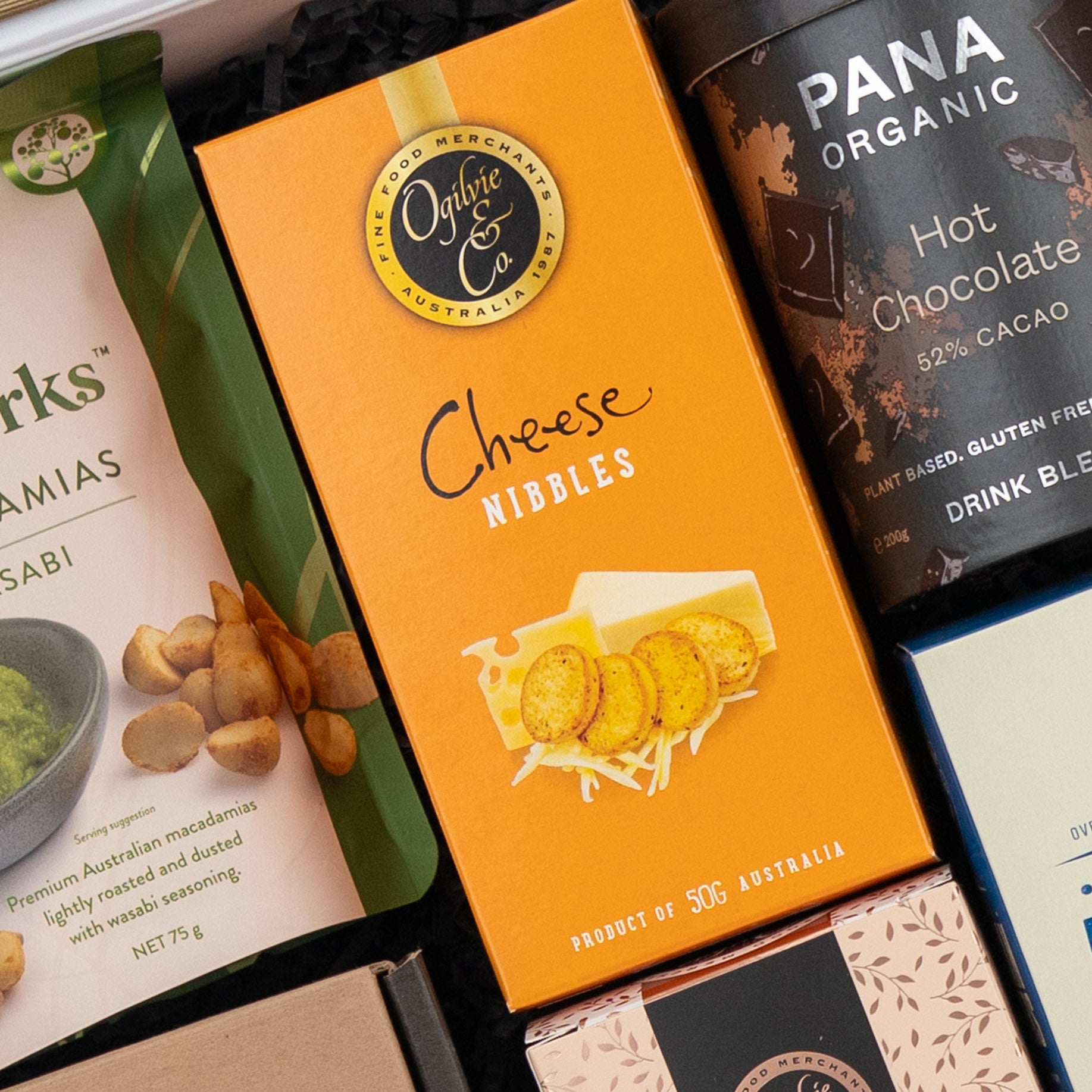 A close-up of a Four Pillars Ultimate Gin Experience Hamper by The Hamper Boutique Co, featuring premium gin and an assortment of gourmet treats.