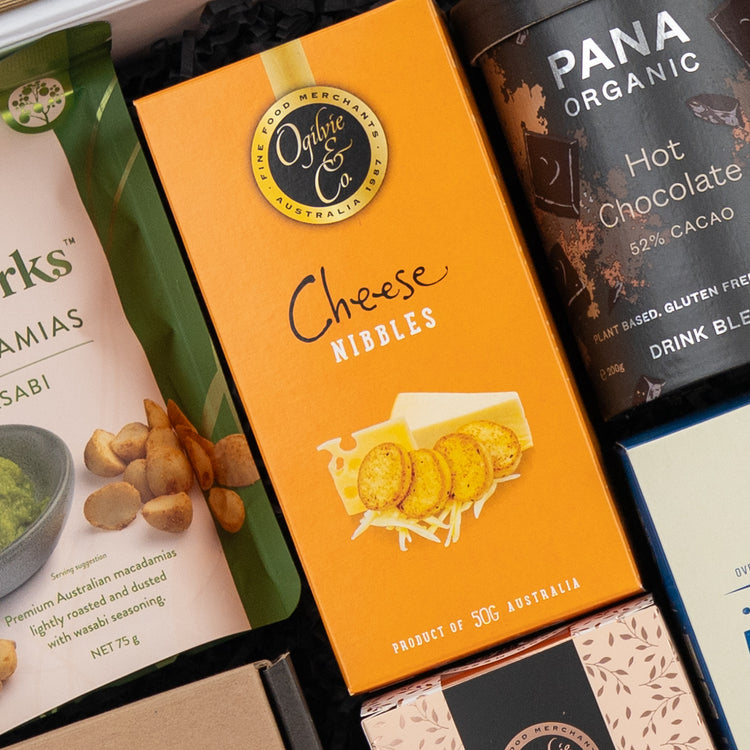 A close-up of a Four Pillars Ultimate Gin Experience Hamper by The Hamper Boutique Co, featuring premium gin and an assortment of gourmet treats.