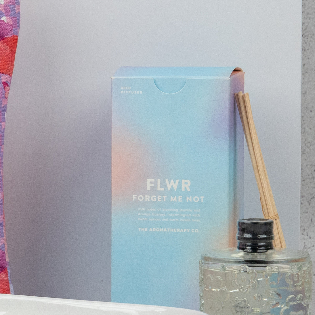 Homeware Selection Hamper box beside a glass reed diffuser