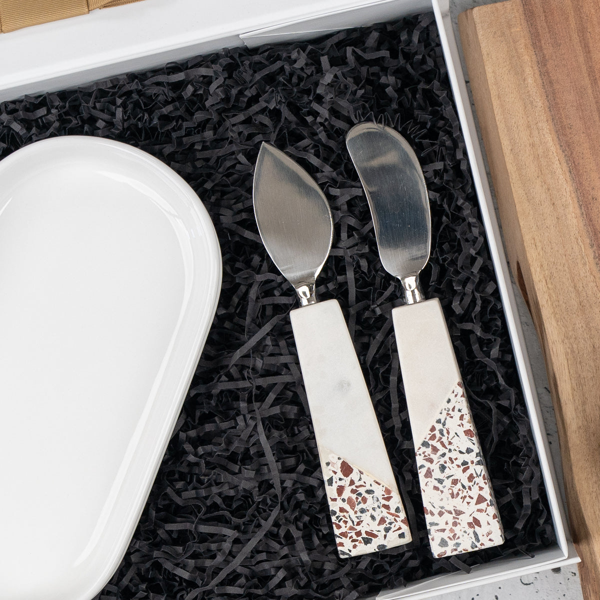 Luxe Homeware Hamper: terrazzo-handled cheese knives beside a white oval dish in the gift box