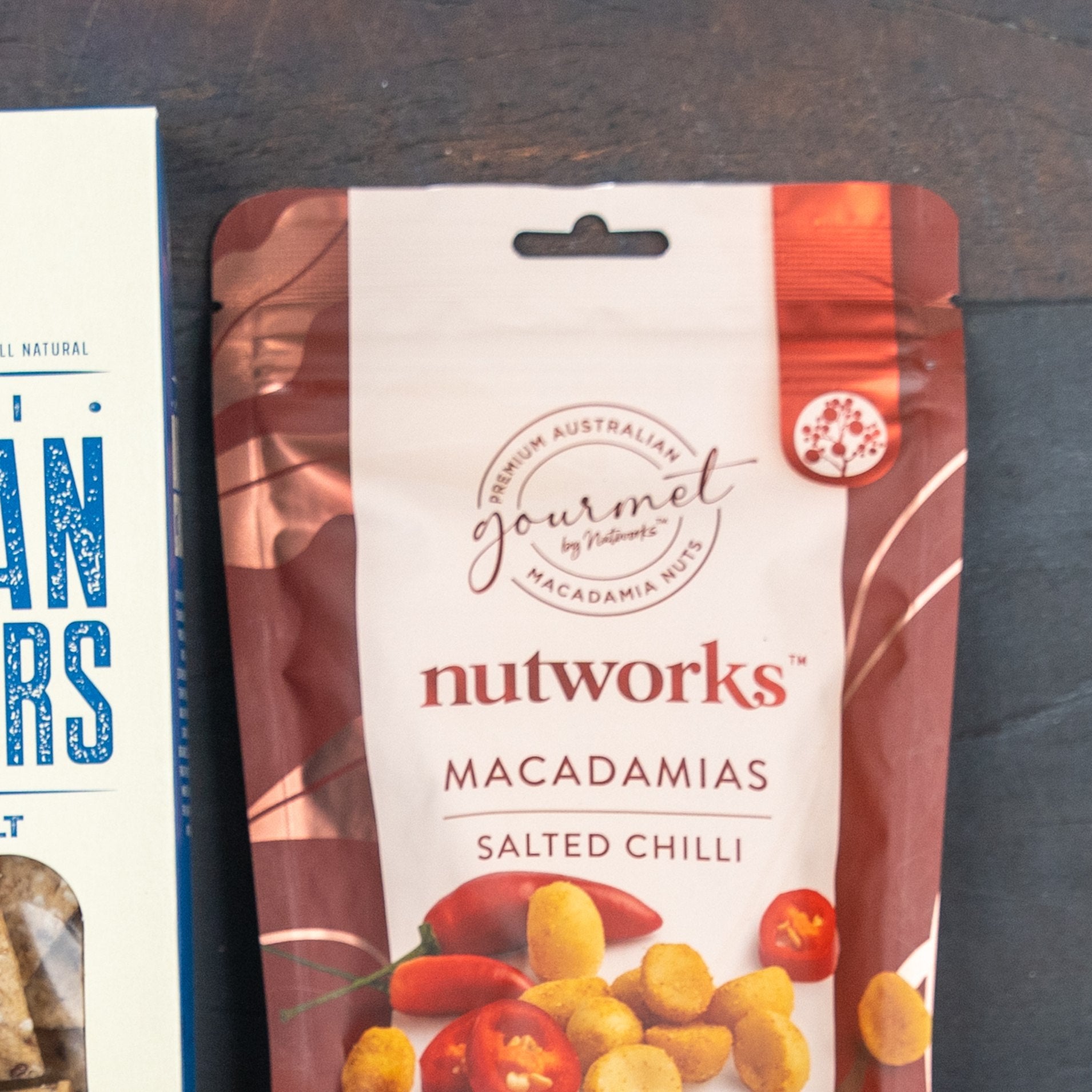 A Savoury Selection Gift Hamper from The Hamper Boutique Co is partly visible on a dark surface beside another product box on the left side of the image.