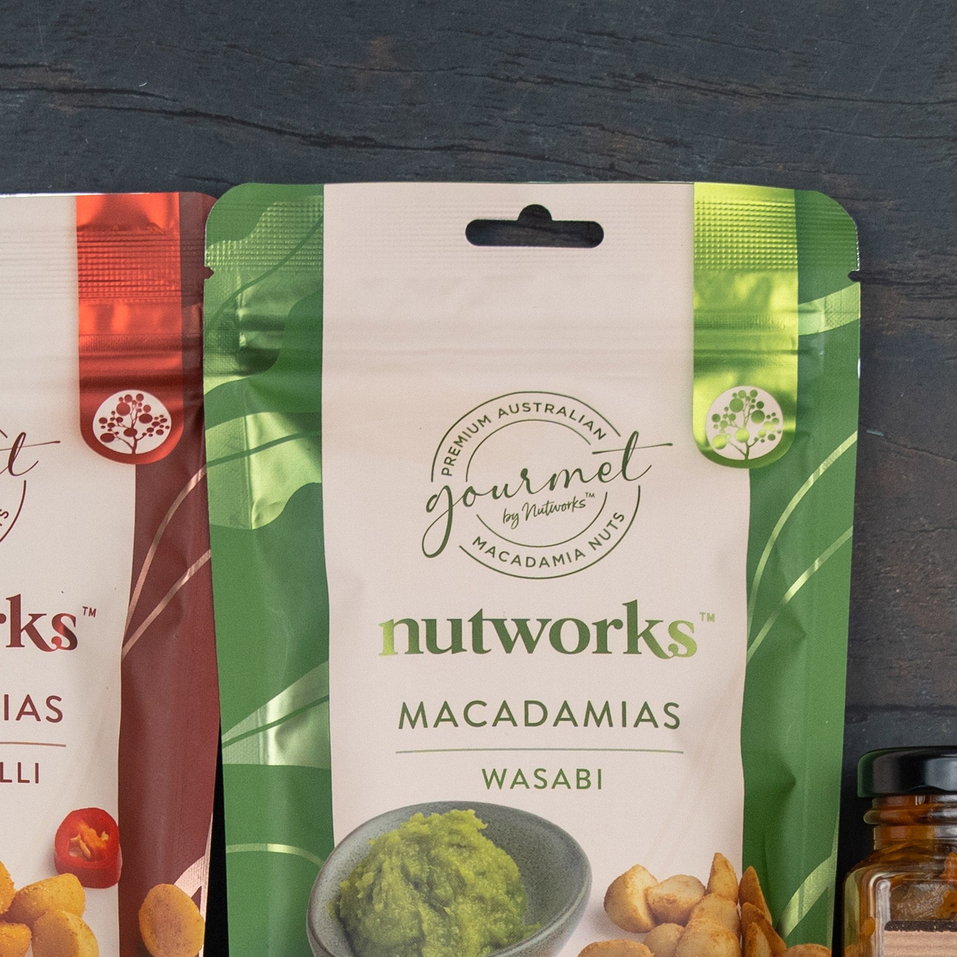 A Festive Treats Gift Hamper from The Hamper Boutique Co sits on a dark surface. The packaging displays festive imagery, and part of another product appears on the left.