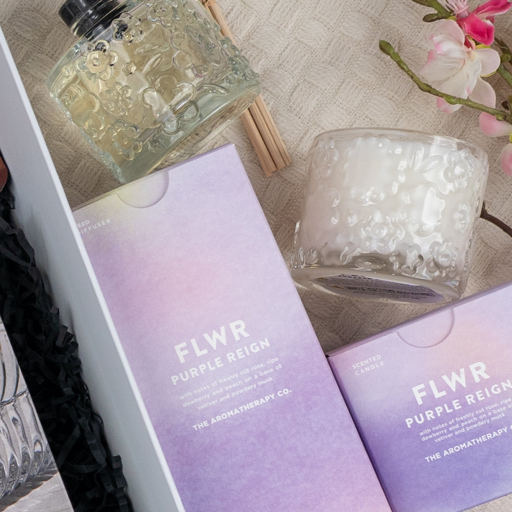 A flat lay featuring The Hamper Boutique Co's Luxe Dining Red Wine Hamper, elegantly arranged on a textured surface with a pink flower branch nearby.