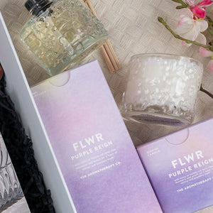 A flat lay featuring The Hamper Boutique Co's Luxe Dining Red Wine Hamper, elegantly arranged on a textured surface with a pink flower branch nearby.