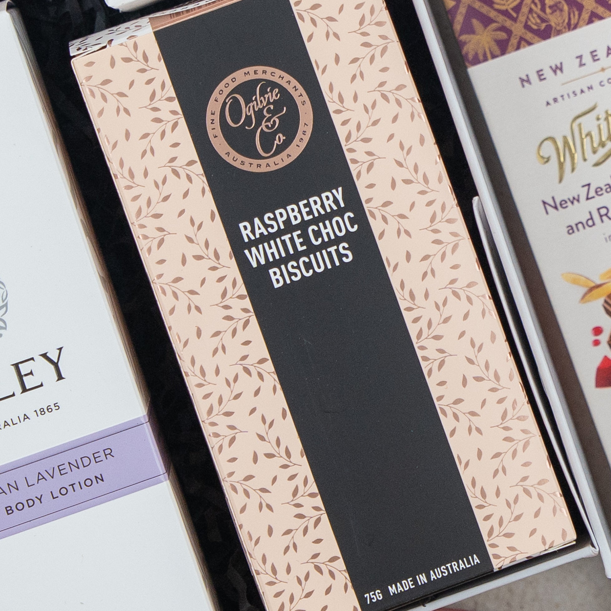 A box from The Hamper Boutique Co’s Chandon Rosé Luxury Selection Hamper sits among other packaged products, featuring elegant branding and premium contents.