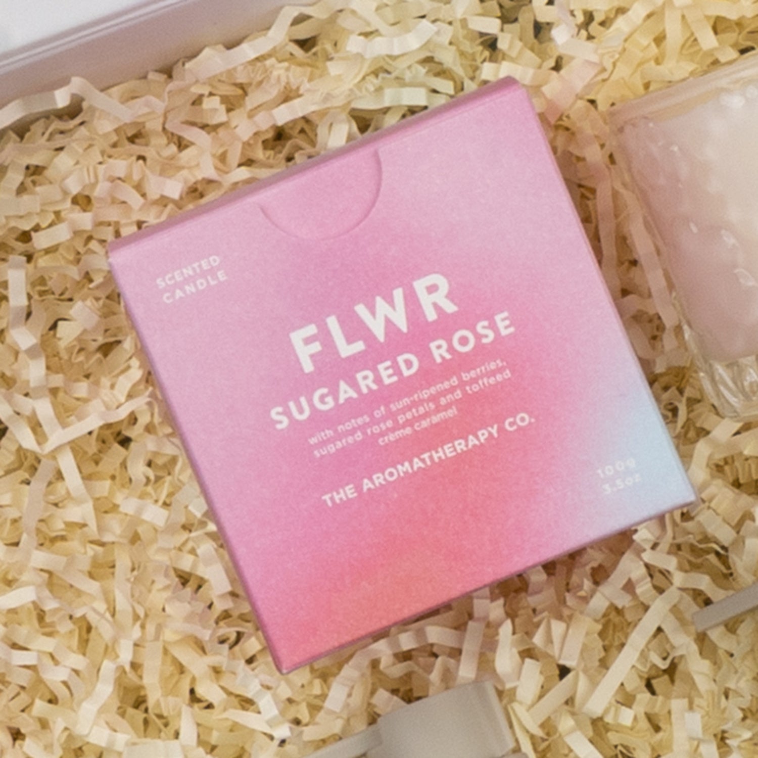 A pink box labeled Veuve Clicquot Premium Celebration Hamper by The Hamper Boutique Co sits on crinkled paper packaging.