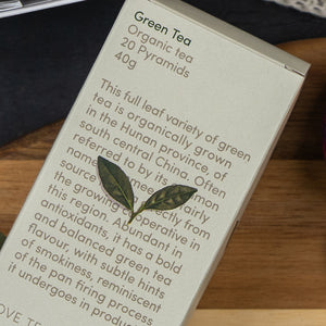 The Cozy Moments Tea Hamper by The Hamper Boutique Co features green tea with side details on variety, Hunan province origin, flavor profile, and growing conditions.