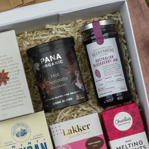 A gift box by The Hamper Boutique Co, the Premium Tea Experience Hamper, featuring premium teas and treats, beautifully presented in shredded paper.