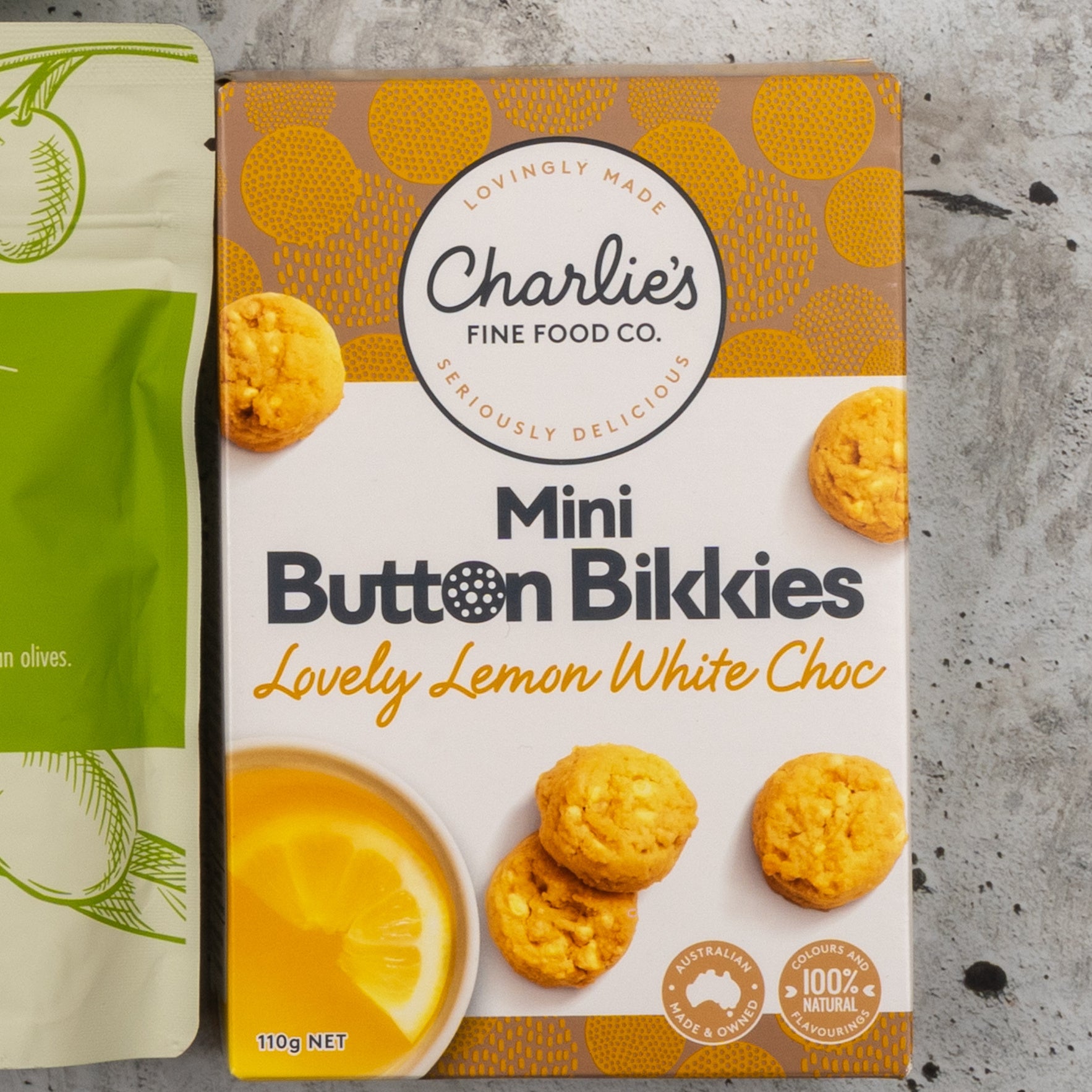 A Gourmet Treats Gift Hamper from The Hamper Boutique Co is shown, with images of cookies and a lemon slice next to a green package displaying partial text.