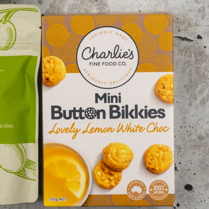 A Gourmet Treats Gift Hamper from The Hamper Boutique Co is shown, with images of cookies and a lemon slice next to a green package displaying partial text.