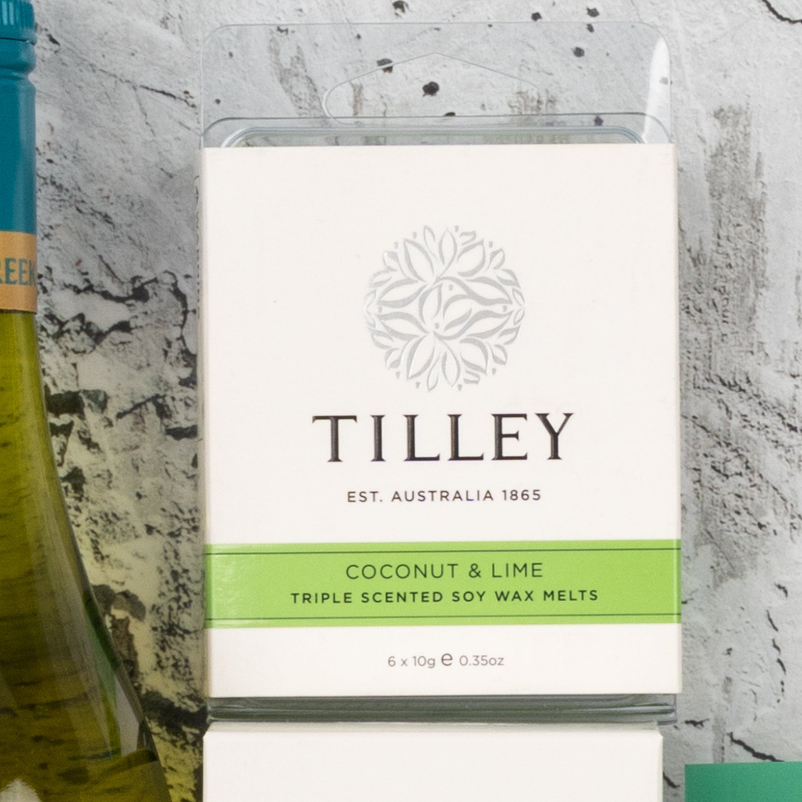 A Spa Day Retreat Gift Hamper by The Hamper Boutique Co, with a white and green design and branding on the front. Part of a bottle can be seen to the left.