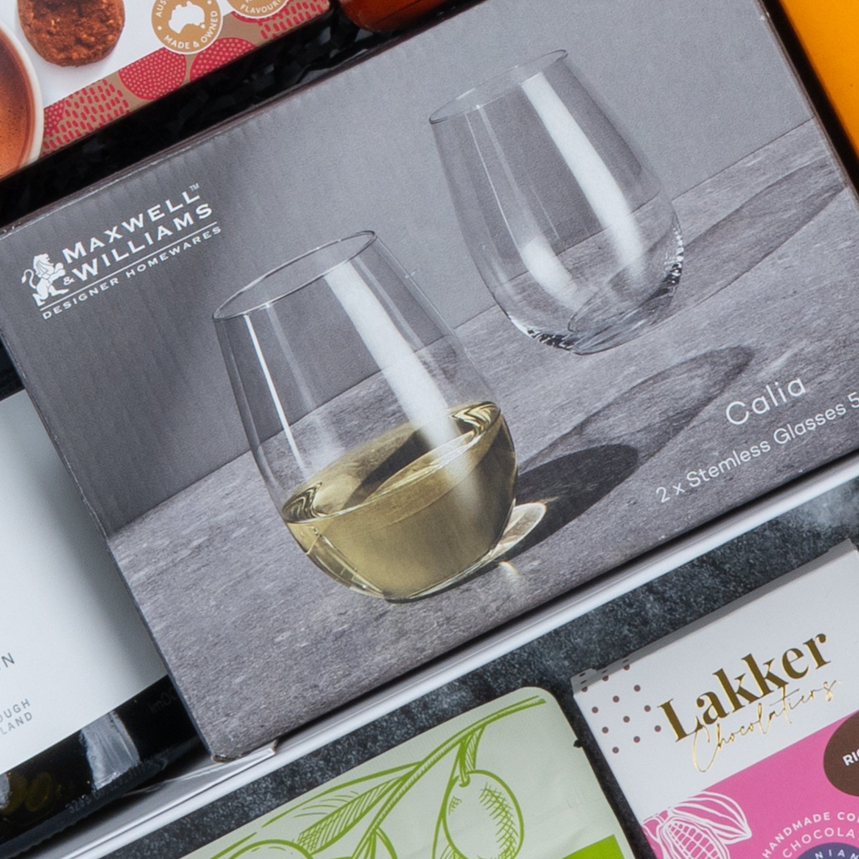 A box of The Hamper Boutique Co Epicurean Delights Hamper, with its packaging shown and other boxes partly visible in the background.