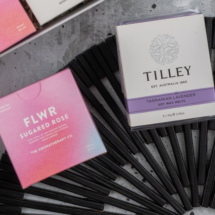 A flat lay photo showing a box labeled Chandon Rosé Pamper Hamper by The Hamper Boutique Co on a black fan and gray surface.
