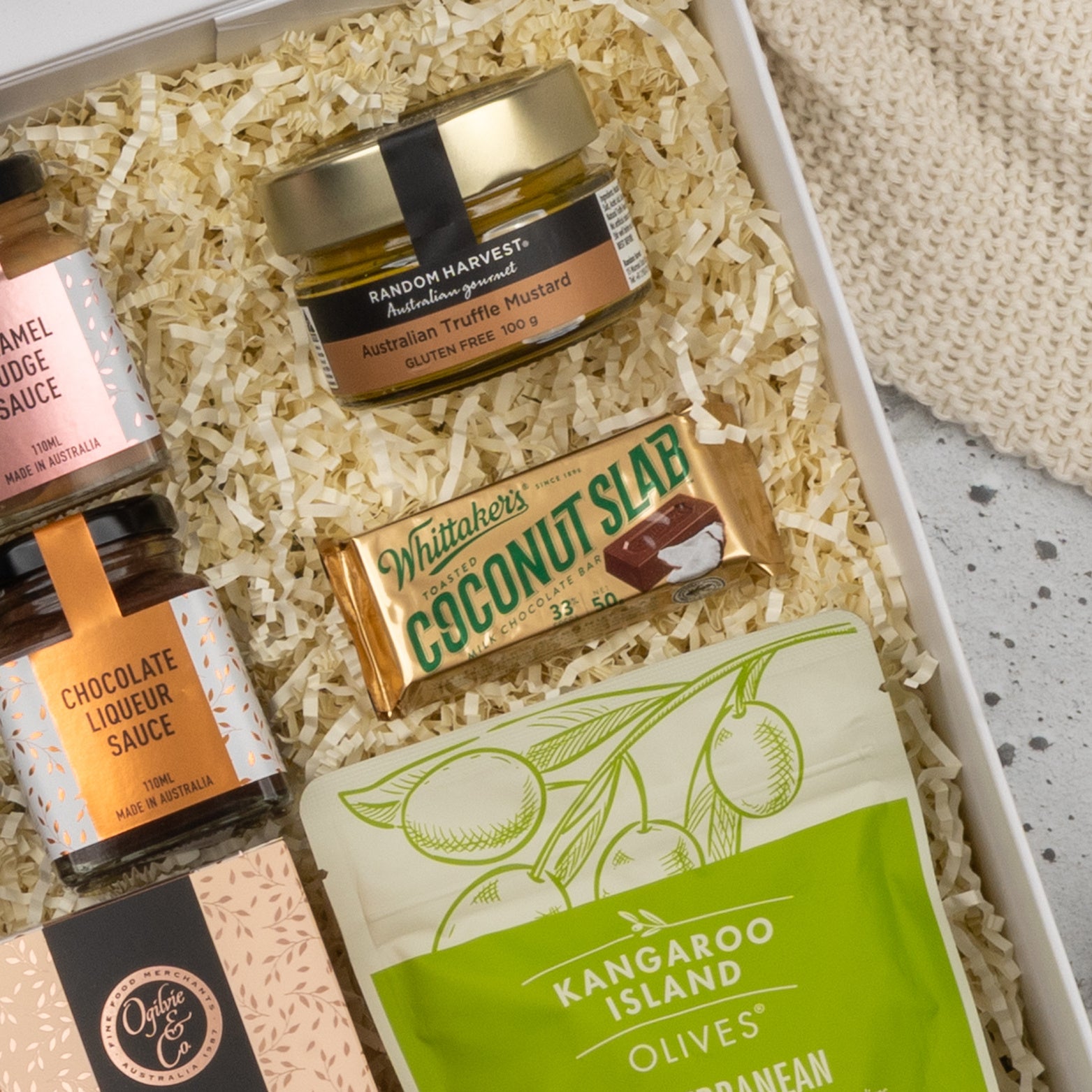 The Hamper Boutique Co’s Chandon Gourmet Celebration Hamper features caramel fudge sauce, chocolate liqueur sauce, truffle mustard, Whittakers Coconut Slab chocolate, and Kangaroo Island olives in a stylish gift box.