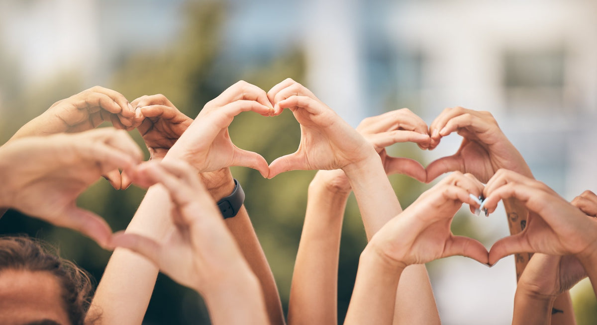Many hands making heart shapes together