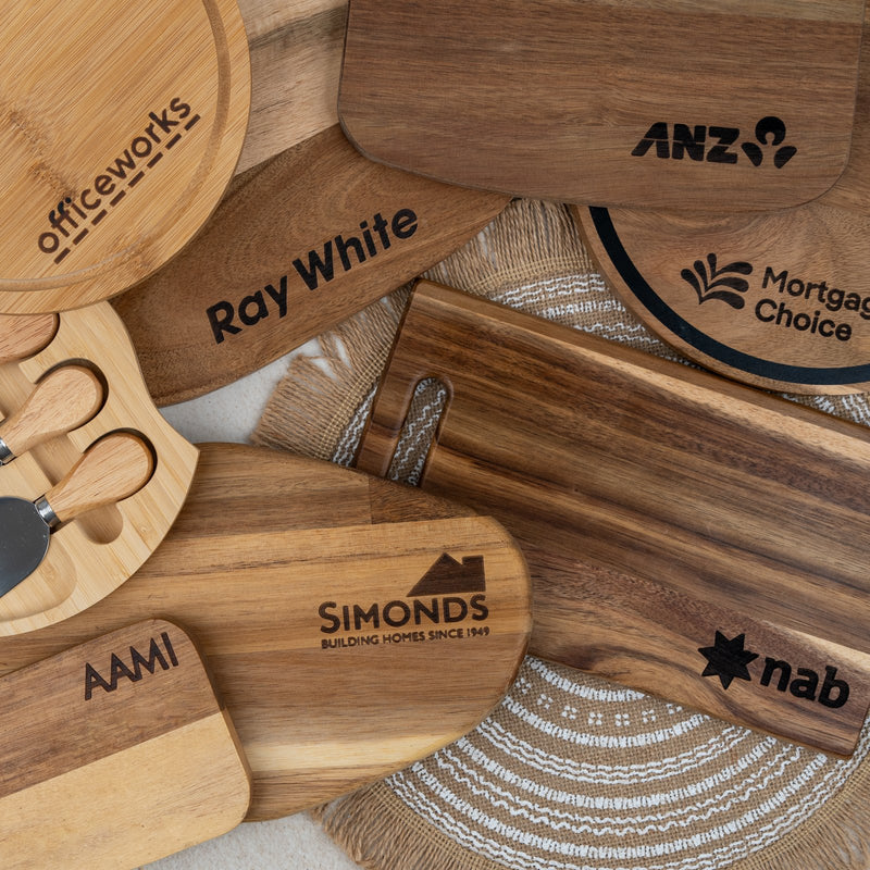 Wooden serving boards engraved with company logos