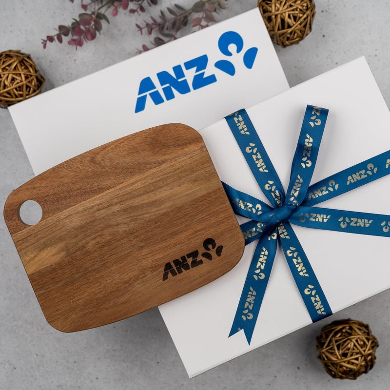 Branded gift box with a printed ribbon and an engraved wooden board